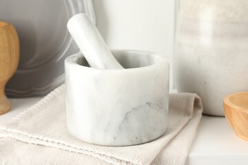 Marble mortar and pestle on white table indoors, closeup