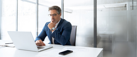 Focused latin senior in suit financial expert analyst thinking on sale solution. Professional...