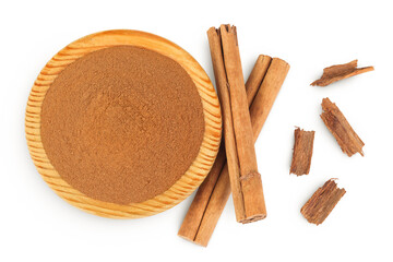 Cinnamon sticks with powder in wooden bowl isolated on white background. Top view. Flat lay