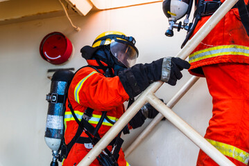 A firefighters climbing the stairs in full protective gear, mask, and oxygen tank stands ready...
