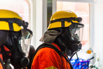 A firefighters in full protective gear, mask, and oxygen tank stands ready during a fire drill on...