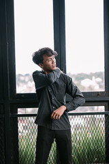 Fototapeta premium Young asian man in casual clothing striking a thoughtful pose indoors