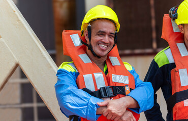 Crew members wear life jackets as they gather for an abandon ship drill, reviewing lifeboat deployment. Their safety gear and focused expressions underscore the critical nature of these exercises.