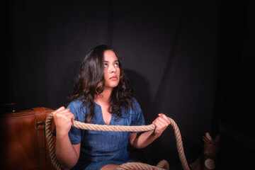 Young woman with rope in her hands looking up