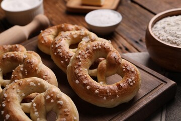 Tasty salted pretzels on wooden table, closeup