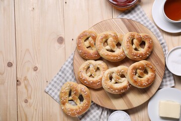 Tasty pretzels, ingredients and tea on wooden table, flat lay. Space for text