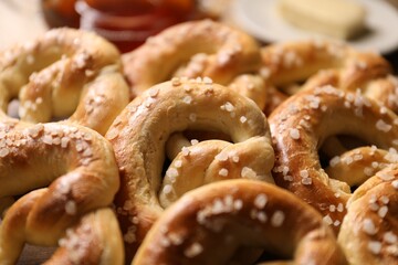 Many tasty salted pretzels on table, closeup