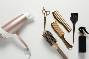 Different hairstyling tools on white background, flat lay