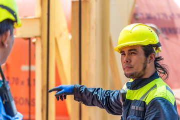 Portrait of a young Filipino marine engineer aboard a large container ship, gazing ahead with a...
