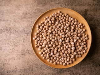 Raw Chickpeas on a rustic wooden table. Dry chickpea background close up. Chickpea legumes seed background.