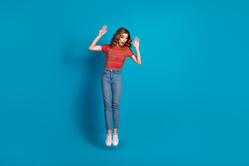 Lovely girl with trendy style posing playfully against a vibrant blue background, conveying charm, confidence
