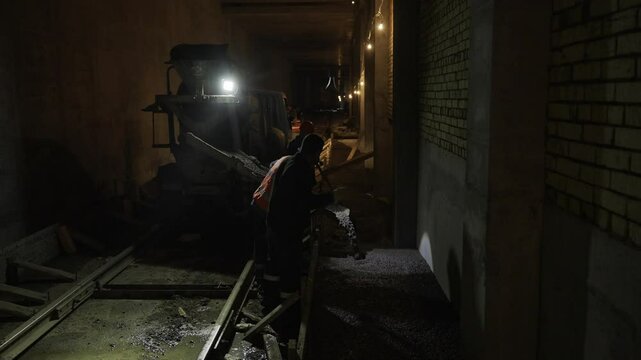 Experienced workers diligently work in tunnel of metro new line. Reinforced concrete ensures stability for years of safe underground transit