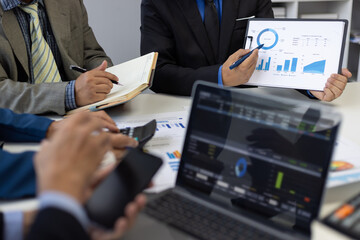 Businessman analyzing financial chart and report using laptop computer. Business people working...