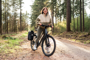 Fototapeta premium Capturing the moment, a cheerful traveler cycles through golden woods, where self-care meets adventure