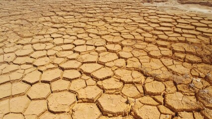 Abstract view of cracked dry desert floor forming natural hexagonal patterns T