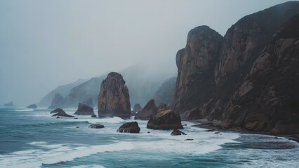 Wild rocky shoreline against endless grey ocean under heavy sky Stark loneline