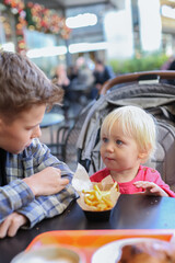 Father having lunch with sons in the shopping centre