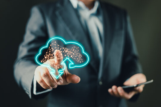 A businessman uses a tablet while interacting with a glowing cloud icon, symbolizing digital data upload and download processes, cloud computing, storage solutions, and modern network connectivity.