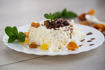 sweet breakfast in a plate with cottage cheese in chocolate syrup with candied fruits