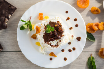 sweet breakfast in a plate with cottage cheese in chocolate syrup with candied fruits