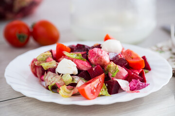 Diet salad with mozzarella and beetroot on a light wooden table