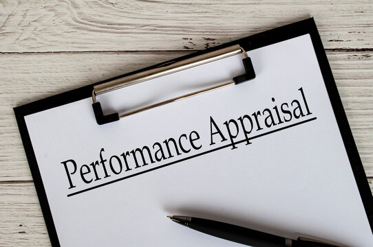 Clipboard with a document titled Performance Appraisal text, placed on a white wooden surfac