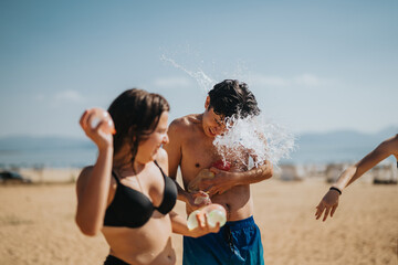 Two friends engage in a joyful water balloon fight on a sunny beach day, capturing the fun and...