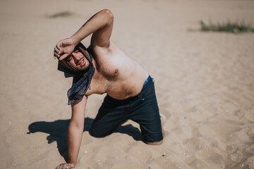 A person kneels on a sandy surface, shielding their eyes from the intense sunlight. The image evokes a sense of struggle in a dry, hot desert-like environment, emphasizing heat and survival.