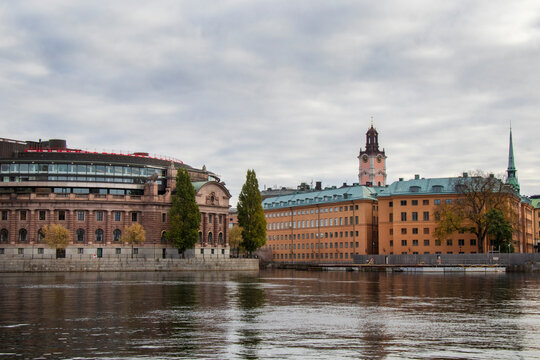 Waterfront Architecture with Historic and Modern Buildings in. Stockholm, Sweden. View of historic and modern buildings along riverbank under cloudy sky.