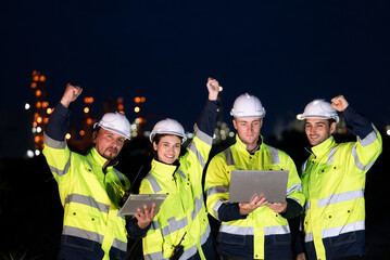 Group of engineer raising hands up for finish working night shift at petrochemical refinery oil...