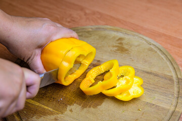 Woman cutting bell pepper on a cutting board