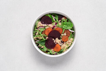 Quinoa salad with arugula, beetroot and carrot. Detox, diet, healthy salad in white bowl on light background