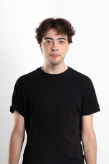 Fototapeta premium Portrait of the torso and face of a serious young Latin man in a white indoor