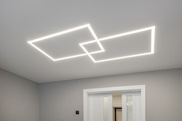 suspended ceiling with halogen spots lamps in form of squares and rectangles and drywall...