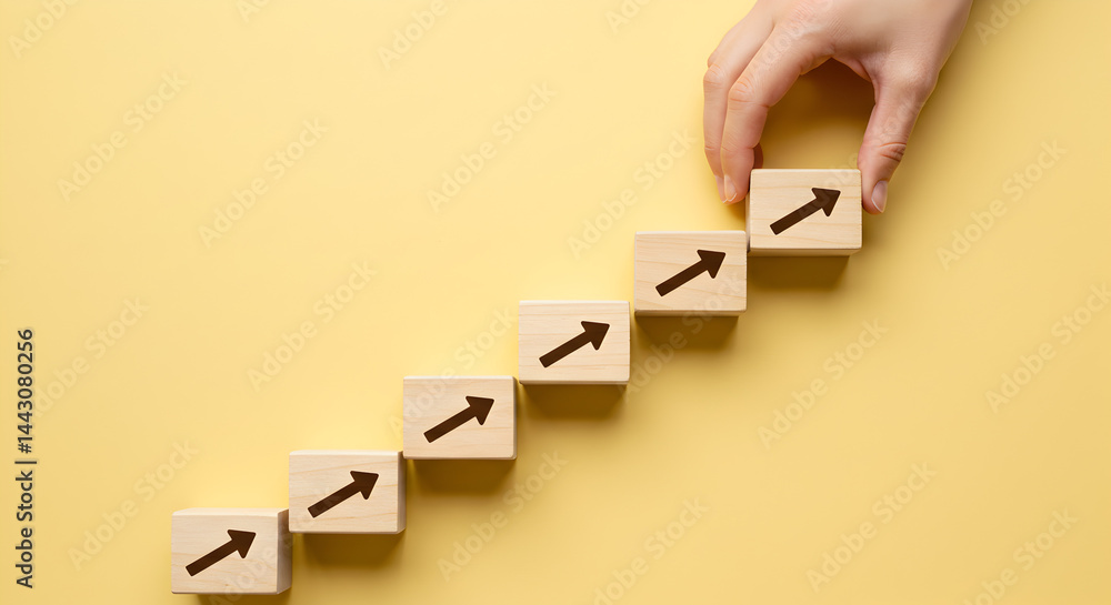Aufkleber hand arranging wooden blocks with arrow graphics in ascending order on yellow background