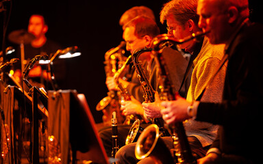 Big Band Saxophones. A view across the sax section in a big band performing together live on stage.