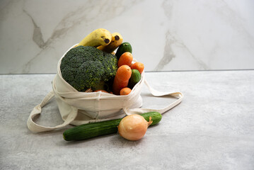 Reusable fabric beige bag filled with fresh vegetables. Sustainable lifestyle