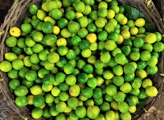 Organic Fresh Green Lemons in Woven Basket for Market Sale and Culinary Use