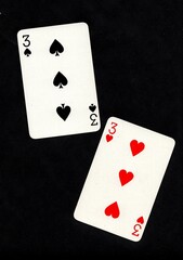 Obraz premium A pair of playing cards of the same value isolated on a black background.