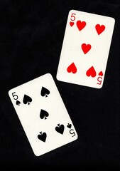 A pair of playing cards of the same value isolated on a black background.