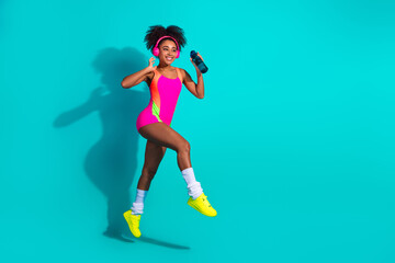 Energized young woman in bright athletic wear posing enthusiastically, epitomizing active...