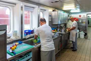 Ship's cooks at work in the galley of a merchant vessel—focused, skilled, and essential to daily...