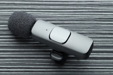 Lavalier microphone on black wooden table, closeup