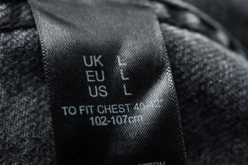 Clothing label with size and material content on garment, closeup