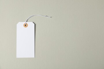 Blank tag with string on grey background, top view. Space for text