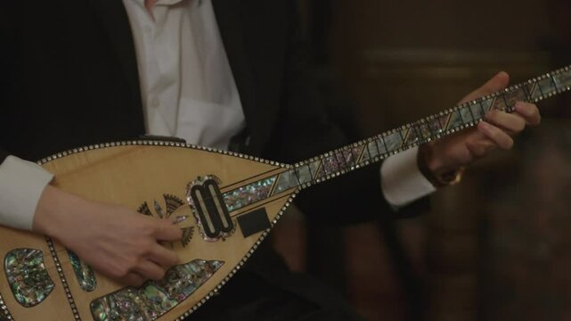 Musician man playing traditional saz instrument on stage