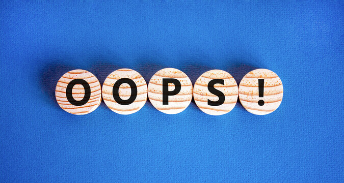 Oops symbol. Concept word Oops on beautiful wooden circles. Beautiful blue table blue background. Business lifestyle oops concept. Copy space.