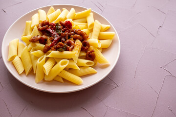 Close-up of penne pasta with shrimps on a plate, Mediterranean style with tomatoes