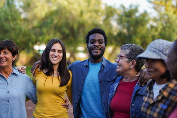 Multi generational diverse people hugging each other at city park - Multiracial community and social inclusion concept