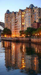 City apartments reflected in calm water at dawn